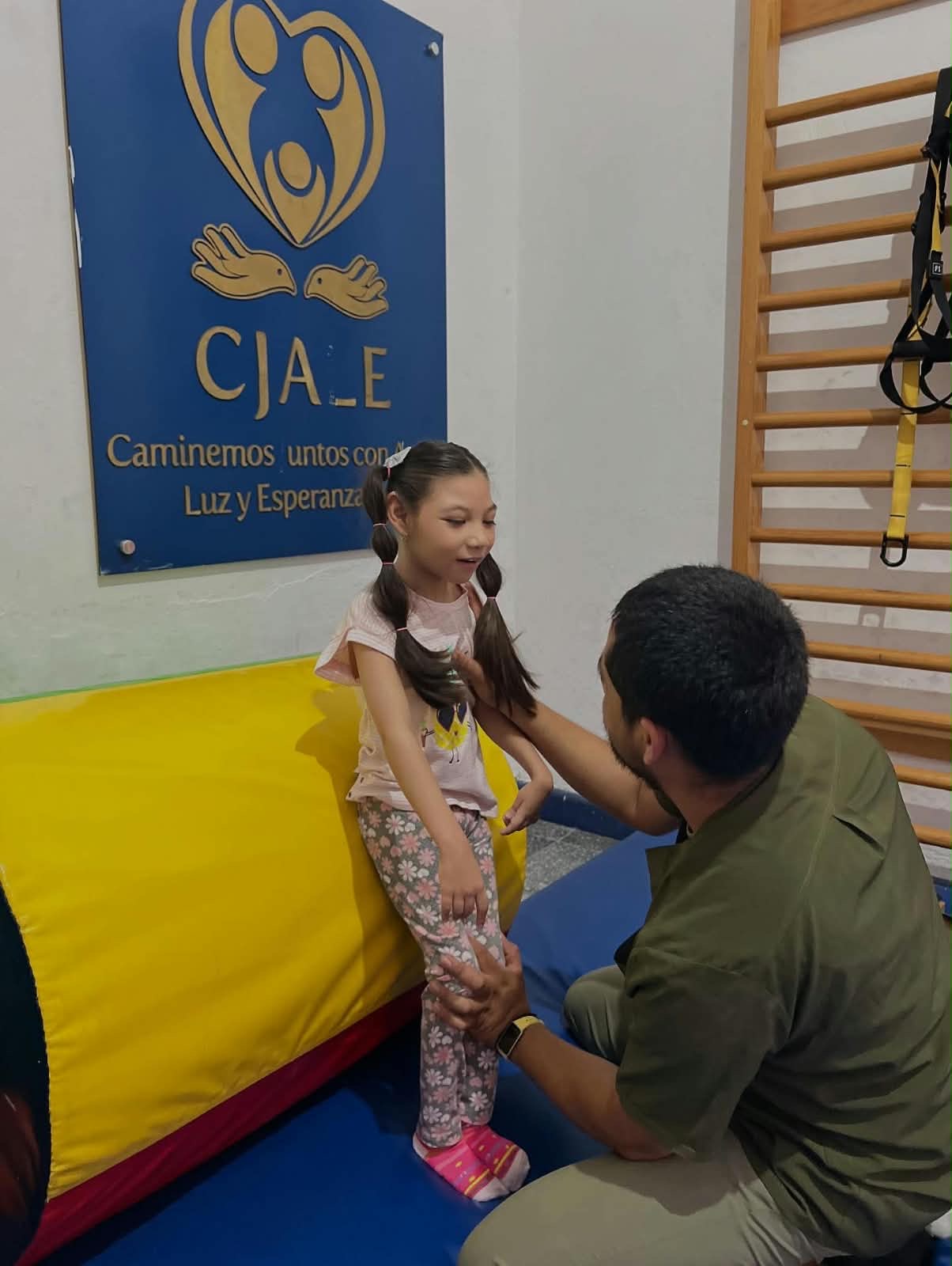 A Caminemos Juntos therapist supporting a child during rehabilitation
